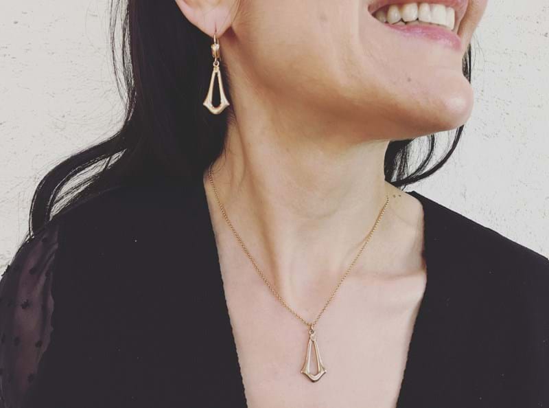 Model wearing Adorn yellow gold dangly earrings and matching pendant, jewellery, Melbourne Australia